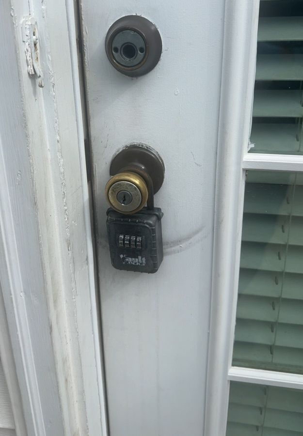 Old deadbolt and worn knob on a Charlotte home before replacement