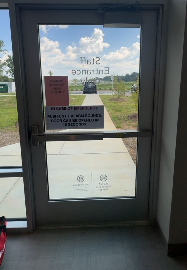 Staff entrance door with a detached closer arm before repair, Concord NC