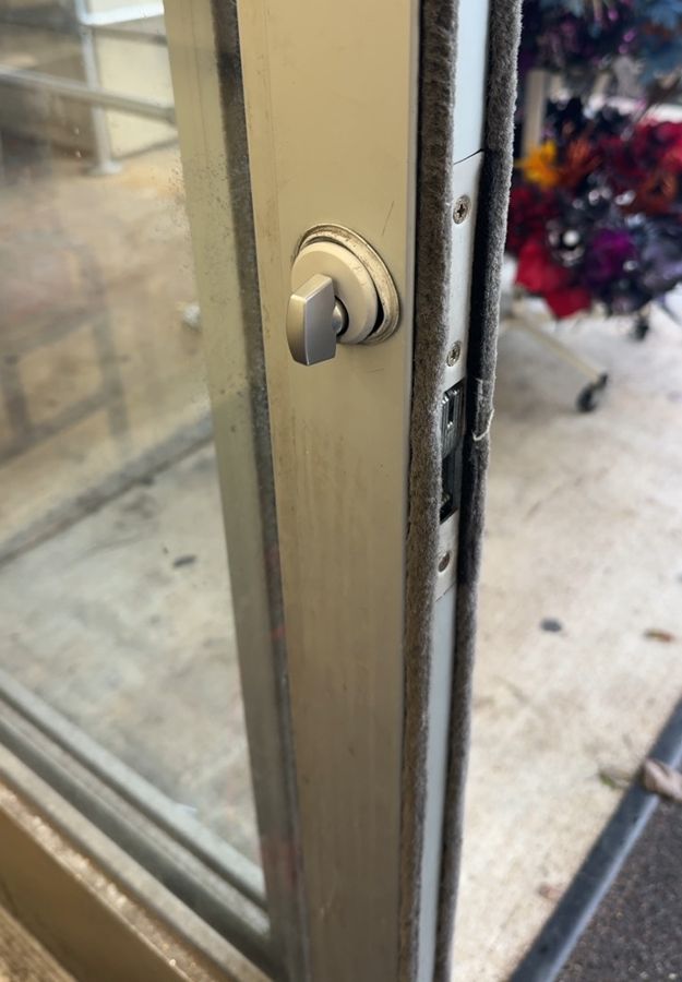 Old thumb turn on the inside of an aluminum storefront door before replacement, Kannapolis NC